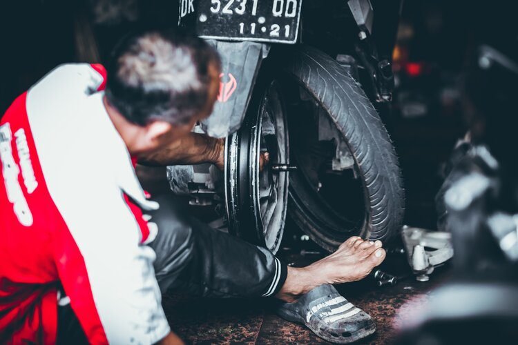 Malaysian mechanic changing motorcycle tyre