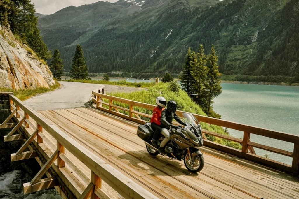 bmw rider and passenger crossing wooden bridge