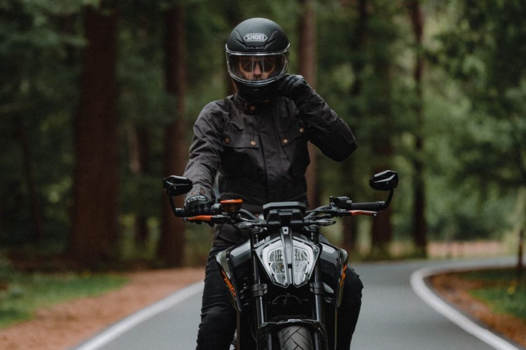 rider on road lines with trees