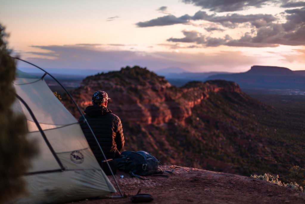 guy camping in mountains - sleeping mats & pads motorcycle camping