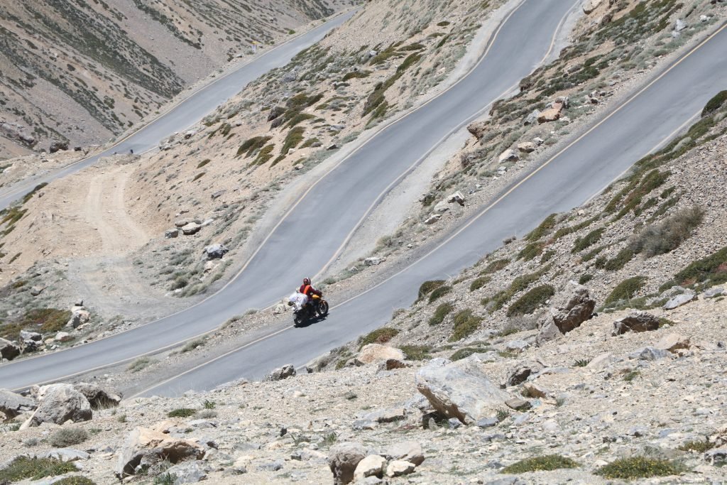 lone biker on mountain road - motorcycle touring as an introvert