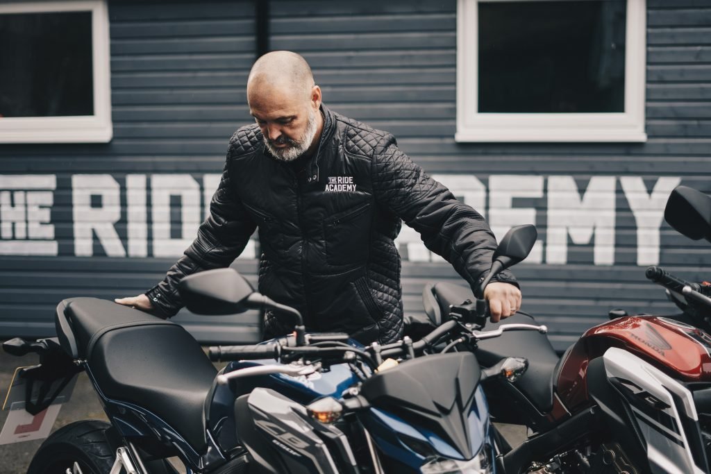 man pushing motorcycle