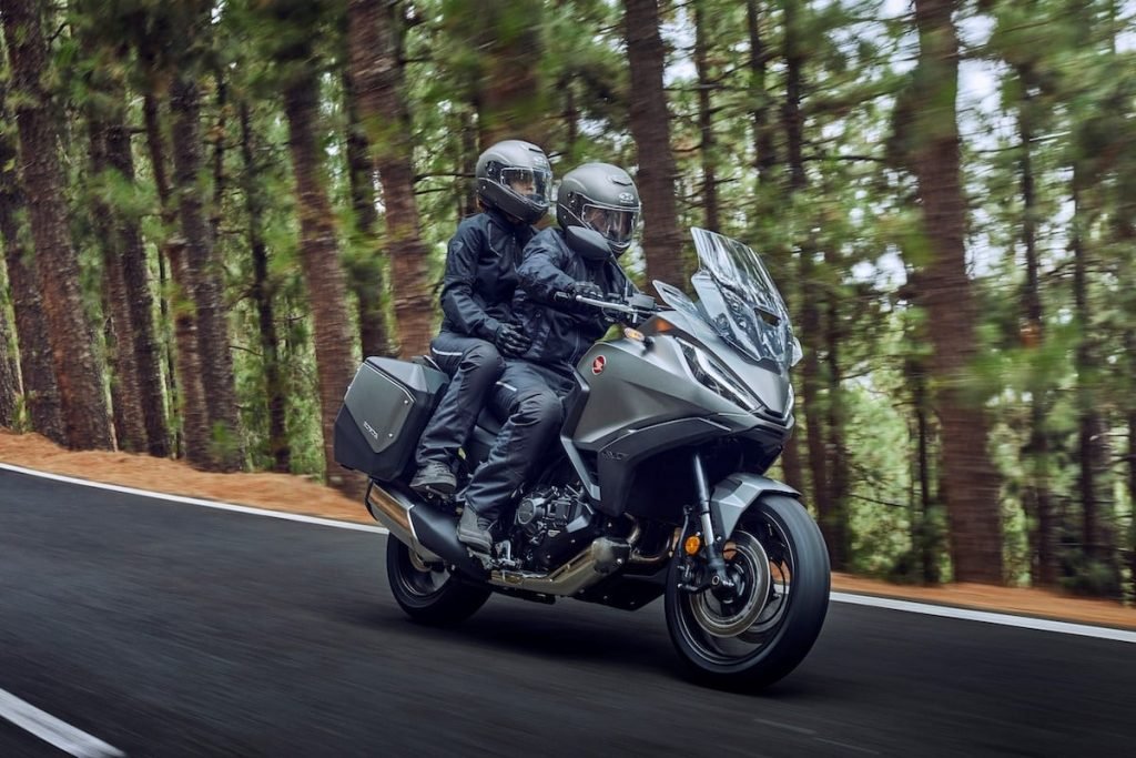 Honda NT1100 riding through forest with pillion - motorcycle touring trends