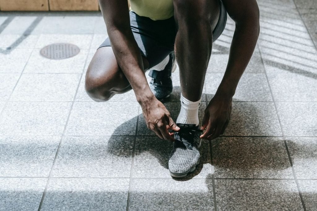 guy lacing up running shoes