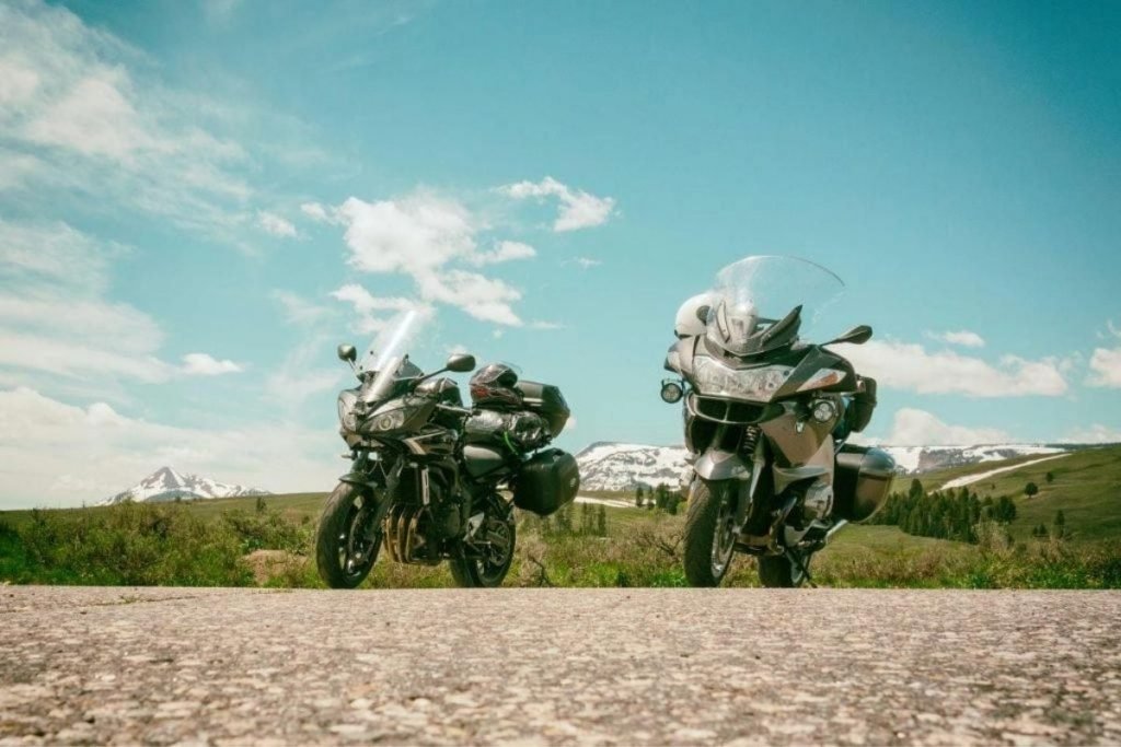 motorcycles on road with snow-capped mountains