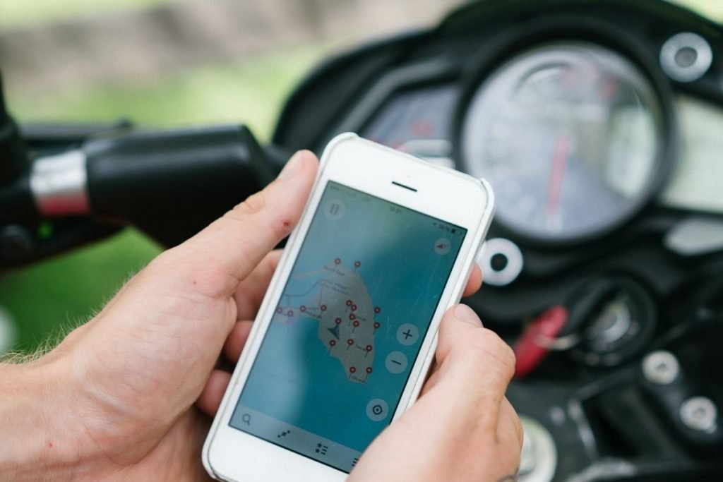 biker checking sat nav on smartphone - motorcycle route planning app