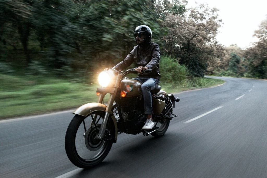 riding motorbike on twisty road - motorcycle touring on a budget