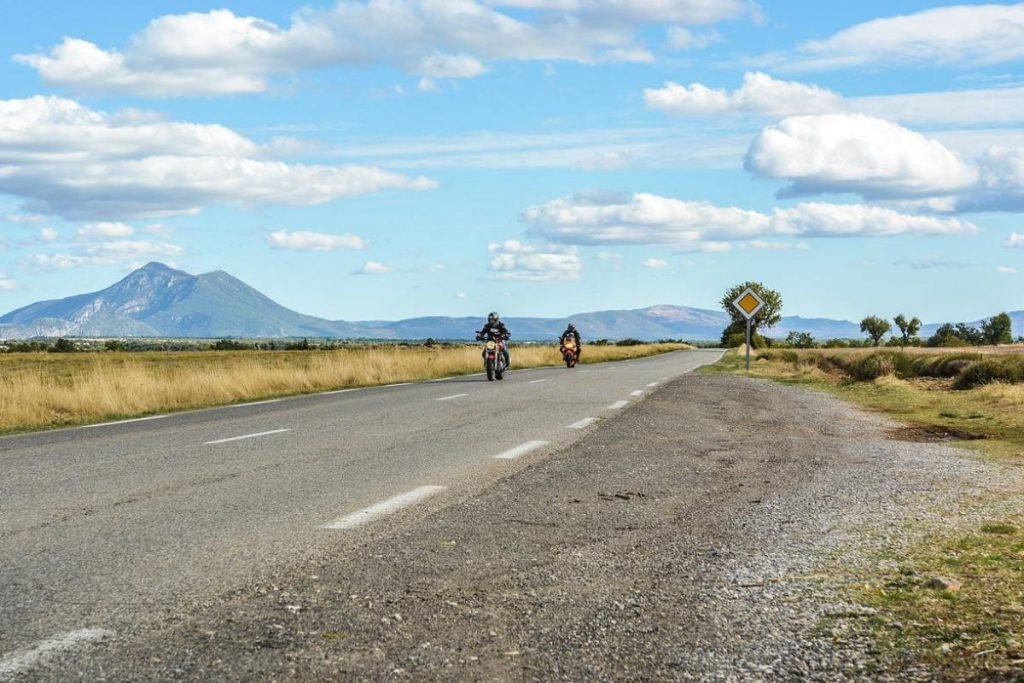 bikers riding by mountains