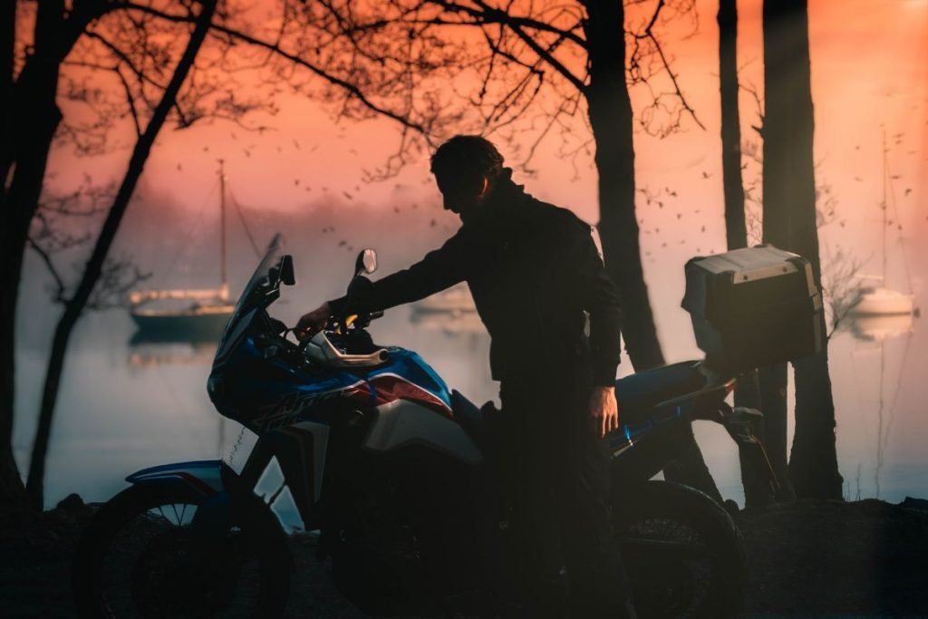 rider and africa twin with boats