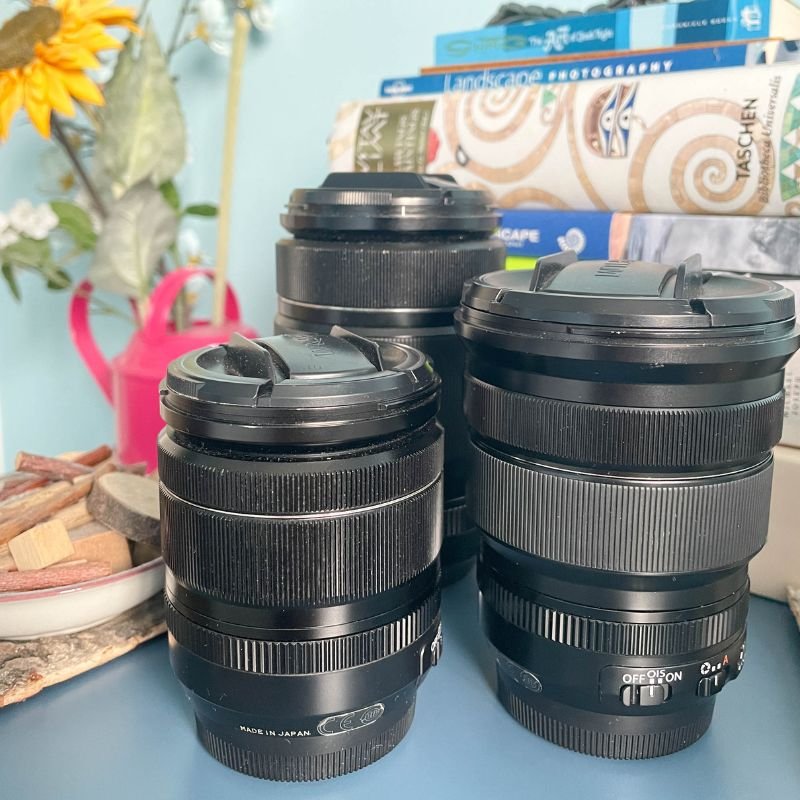 fujinon lenses on blue shelf with books and sunflower