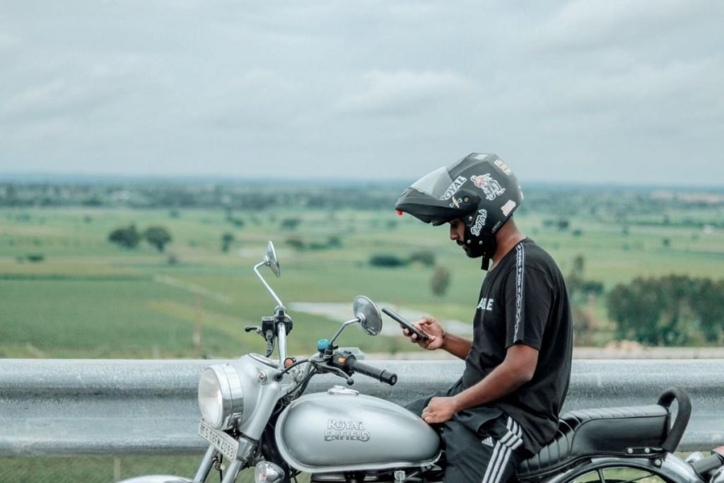 best motorcycle smartphone holders - rider using phone on royal enfield