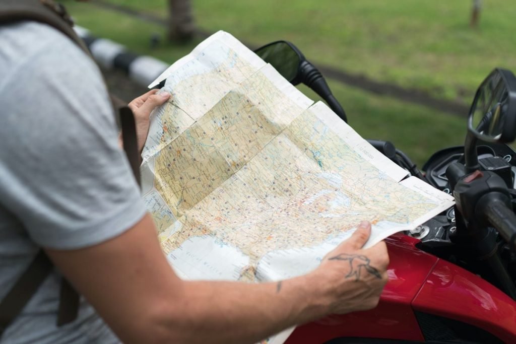 biker with paper map - Motorcycle Camping Gear Checklist