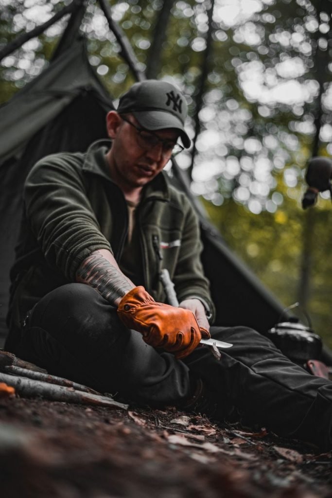 camper with multi-tool sharpening stick - Motorcycle Camping Gear Checklist