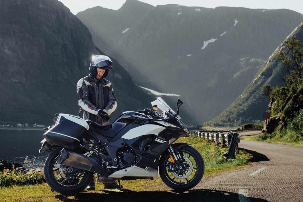 rider on winding road in senja in sunshine